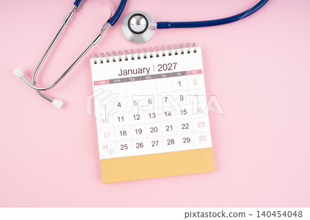 January 2027 desk calendar and Medical stethoscope on  pink background. 140454048