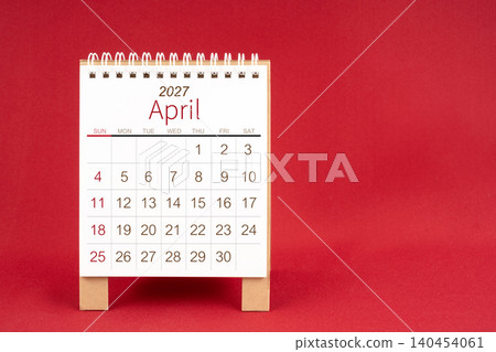 Blank desk calendar for April 2027 on red background. Blank desk calendar for April 2027 on red background. 140454061