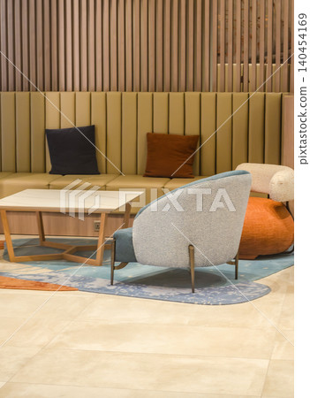Modern lounge interior with designer armchair, upholstered bench, marble coffee table and blue rug against warm wood slat wall, contemporary hotel lobby decor.. High quality photo Modern lounge interior with designer armchair, upholstered bench, marble coffee table and blue rug against warm wood slat wall, contemporary hotel lobby decor.. High quality photo 140454169