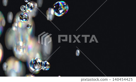 3D render of liquid spheres with iridescent effect and rainbow chromatic aberration. Defocused liquid bubbles floating in empty space on a soft black background. 3D render of liquid spheres with iridescent effect and rainbow chromatic aberration. Defocused liquid bubbles floating in empty space on a soft black background. 140454425