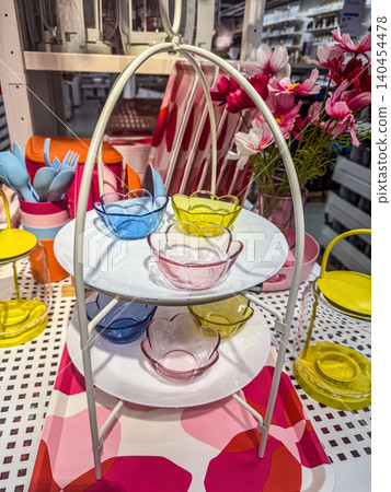 Two Tiered White Serving Stand with Colorful Flower-Shaped Glass Bowls on a Pink Floral Tray for Spring Party Table Decor Two Tiered White Serving Stand with Colorful Flower-Shaped Glass Bowls on a Pink Floral Tray for Spring Party Table Decor 140454478