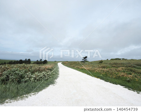 A white road on the Soya Hills under a light cloud cover A white road on the Soya Hills under a light cloud cover 140454739