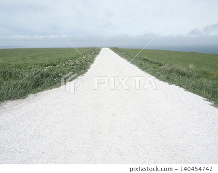 A white road on the Soya Hills under a light cloud cover A white road on the Soya Hills under a light cloud cover 140454742