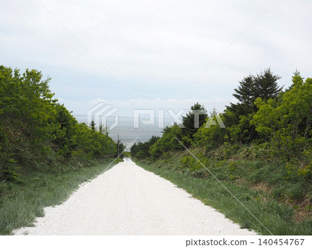 A white road on the Soya Hills under a light cloud cover A white road on the Soya Hills under a light cloud cover 140454767