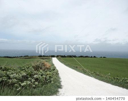 A white road on the Soya Hills under a light cloud cover A white road on the Soya Hills under a light cloud cover 140454770