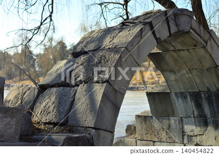 Old broken stone arch by the water Old broken stone arch by the water 140454822