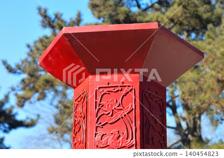 Red carved wooden post outdoors Red carved wooden post outdoors 140454823