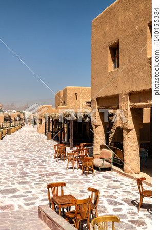 Traditional adobe architecture and outdoor seating along the stone paved street of AlUla Old Town in Saudi Arabia 140455384