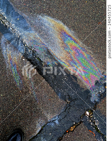 A leaked Car Oil Petrol in The Rain on a Tarmac Road Metallic Rainbow A leaked Car Oil Petrol in The Rain on a Tarmac Road Metallic Rainbow 140455725