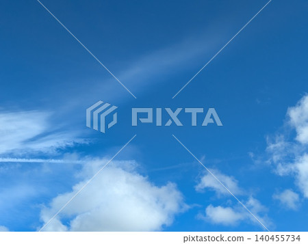 Beautiful blue summer air with fluffy white clouds and chem trail lines across the sky Beautiful blue summer air with fluffy white clouds and chem trail lines across the sky 140455734
