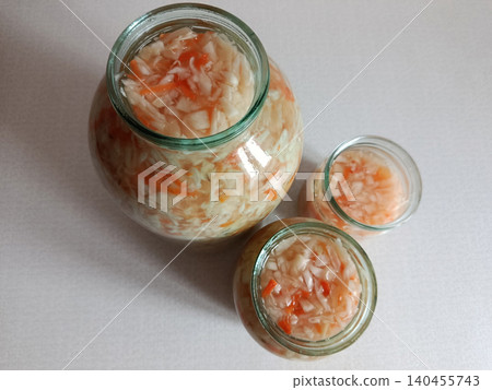 Sauerkraut in glass jars, a traditional fermented food, creating healthy probiotics with cabbage and carrots for a balanced diet and gut health Sauerkraut in glass jars, a traditional fermented food, creating healthy probiotics with cabbage and carrots for a balanced diet and gut health 140455743
