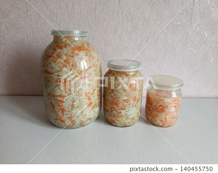 Homemade fermented cabbage and shredded carrots with spices in clear glass jars, preparing traditional eastern european sauerkraut for healthy probiotic food storage Homemade fermented cabbage and shredded carrots with spices in clear glass jars, preparing traditional eastern european sauerkraut for healthy probiotic food storage 140455750