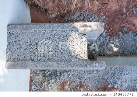Top-down detailed shot of a hollow concrete block filled with crushed stones and gravel at a construction site. Perfect for building materials suppliers and structural engineering themes. Industrial 140455771