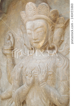 Ancient Buddhist stone carving of serene temple deity Ancient Buddhist stone carving of serene temple deity 140455860
