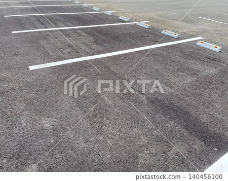 An empty parking lot lined with white lines and bollards. An empty parking lot lined with white lines and bollards. 140456100