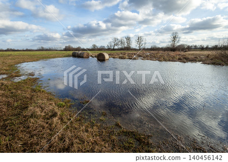 Flooded meadow and clouds in the sky Flooded meadow and clouds in the sky 140456142