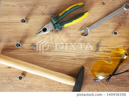 Working tools on wooden background. glasses, pliers, hammer, screwdriver. construction, repair concept Working tools on wooden background. glasses, pliers, hammer, screwdriver. construction, repair concept 140456398