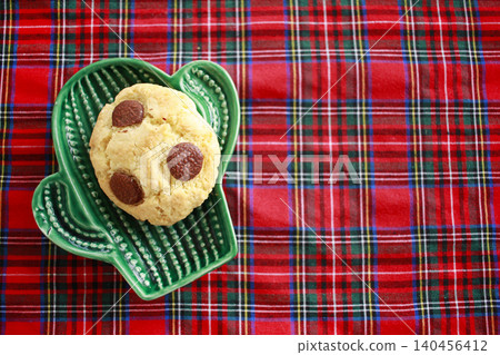 Chocolate cookies on small green plate cactus. Red background Chocolate cookies on small green plate cactus. Red background 140456412