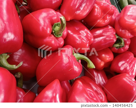 Red bell peppers are filling a frame, showing their smooth, glossy skin and vibrant color, representing fresh vegetables, healthy eating, and organic food choices Red bell peppers are filling a frame, showing their smooth, glossy skin and vibrant color, representing fresh vegetables, healthy eating, and organic food choices 140456425