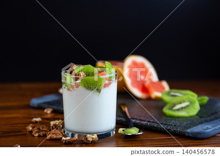 layered yogurt with fresh fruit pieces and walnut topping layered yogurt with fresh fruit pieces and walnut topping 140456578