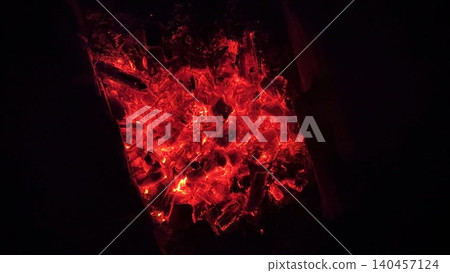 Close up of glowing charcoal embers burning with red and orange tones at night. Soft heat and shimmering texture create magical atmosphere. Warm abstract scene symbolizing warmth and quiet at nature Close up of glowing charcoal embers burning with red and orange tones at night. Soft heat and shimmering texture create magical atmosphere. Warm abstract scene symbolizing warmth and quiet at nature 140457124
