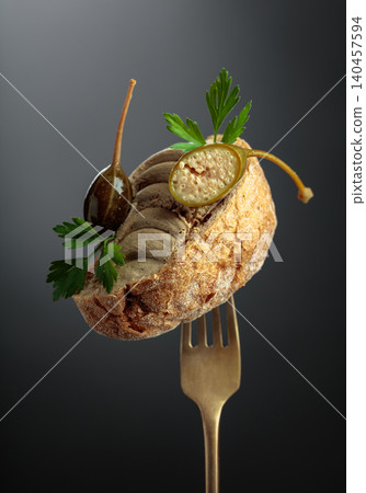 Bread with liver pate, capers, and fresh parsley on a fork. Bread with liver pate, capers, and fresh parsley on a fork. 140457594