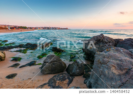 black sea landscape at sunrise. rocks on a sandy beach. sky with clouds glowing in morning light. summer vacation at the sea. bulgaria travel background 140458452
