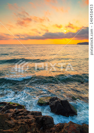 black sea landscape at sunrise. rocks on a sandy beach. sky with clouds glowing in morning light. summer vacation at the sea. bulgaria travel background black sea landscape at sunrise. rocks on a sandy beach. sky with clouds glowing in morning light. summer vacation at the sea. bulgaria travel background 140458453