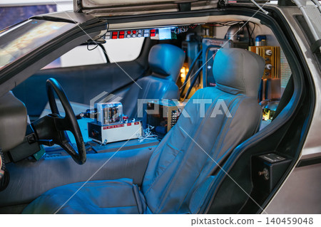 Interior of a modified vehicle showcases advanced technology with illuminated blue and red lights. Features include driver and passenger seats, steering wheel, and a complex control panel in an Interior of a modified vehicle showcases advanced technology with illuminated blue and red lights. Features include driver and passenger seats, steering wheel, and a complex control panel in an 140459048