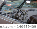 Vintage car dashboard with ornate trim and gauges in showroom 140459409