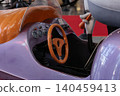 Whimsical toy vehicle with cartoon character holding carrot in amusement park 140459413