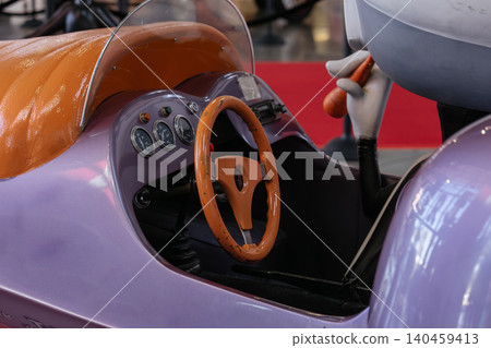 Whimsical toy vehicle with cartoon character holding carrot in amusement park 140459413