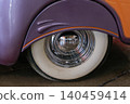 Custom car with polished wheel rim reflecting exhibition hall visitors 140459414