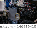 Vintage car engine with radiator and tires in garage setting 140459415