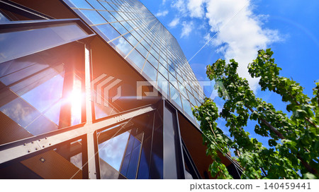 Eco building in modern city concept. Modern office building with the fresh green leaves. Steel and glass. The subject of modern architecture or construction industry. Eco building in modern city concept. Modern office building with the fresh green leaves. Steel and glass. The subject of modern architecture or construction industry. 140459441