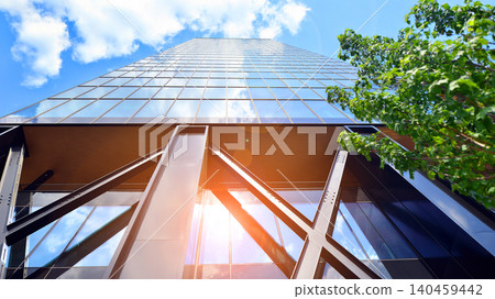 Eco building in modern city concept. Modern office building with the fresh green leaves. Steel and glass. The subject of modern architecture or construction industry. Eco building in modern city concept. Modern office building with the fresh green leaves. Steel and glass. The subject of modern architecture or construction industry. 140459442