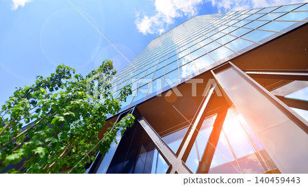 Eco building in modern city concept. Modern office building with the fresh green leaves. Steel and glass. The subject of modern architecture or construction industry. Eco building in modern city concept. Modern office building with the fresh green leaves. Steel and glass. The subject of modern architecture or construction industry. 140459443