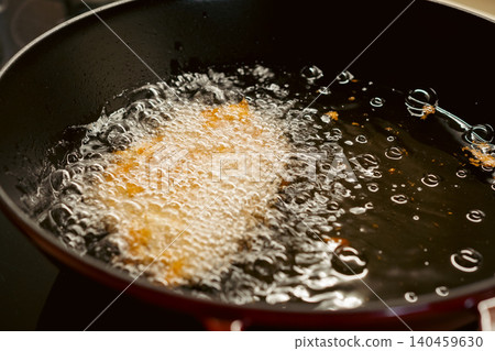 Deep-frying tonkatsu in piping hot oil. (Copy space) Close-up shot. Deep-frying tonkatsu in piping hot oil. (Copy space) Close-up shot. 140459630
