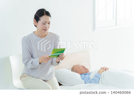 一位神情憂慮的女士看著她的銀行存摺;由於承擔了照顧家人的責任,她已經破產了。 一位神情憂慮的女士看著她的銀行存摺;由於承擔了照顧家人的責任,她已經破產了。 140460066