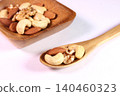 Mixed nuts served on a wooden plate and spoon 140460323