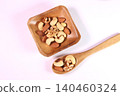 Mixed nuts served on a wooden plate and spoon 140460324