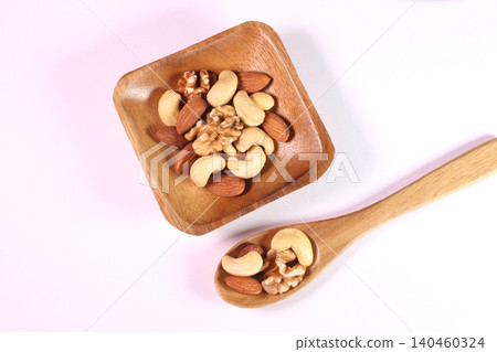 Mixed nuts served on a wooden plate and spoon Mixed nuts served on a wooden plate and spoon 140460324