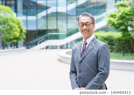 一位商人站在辦公室前 一位商人站在辦公室前 140460413