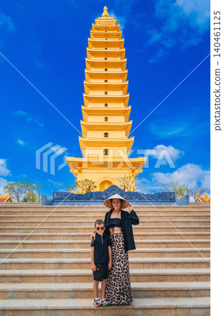 happy tourist family at golden tower on Vietnamese Buddhist pagoda Truc Lam Phung Thuy Son in Nha Trang in Vietnam. Travel, tourism and sightseeing in Asia. Mom and son on a journey happy tourist family at golden tower on Vietnamese Buddhist pagoda Truc Lam Phung Thuy Son in Nha Trang in Vietnam. Travel, tourism and sightseeing in Asia. Mom and son on a journey 140461125
