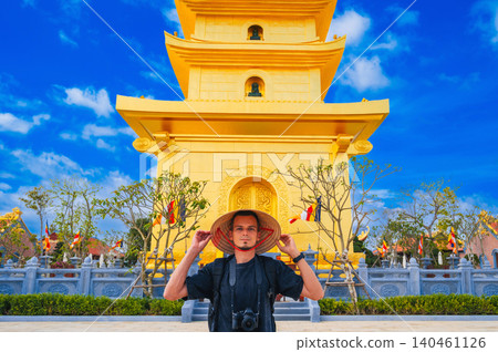 tourist man at golden tower on Vietnamese Buddhist pagoda Truc Lam Phung Thuy Son in Nha Trang in Vietnam. Travel, tourism and sightseeing in Asia tourist man at golden tower on Vietnamese Buddhist pagoda Truc Lam Phung Thuy Son in Nha Trang in Vietnam. Travel, tourism and sightseeing in Asia 140461126