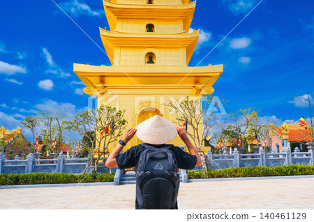 back of tourist male at golden tower on the Vietnamese Buddhist pagoda Truc Lam Phung Thuy Son in Nha Trang in Vietnam. Travel, tourism and sightseeing in Asia 140461129
