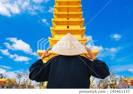 Buddhist tourist girl at the golden tower on Vietnamese Buddhist pagoda Truc Lam Phung Thuy Son in Nha Trang in Vietnam. Travel, tourism and sightseeing in Asia 140461137