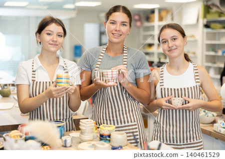 Female teacher and students with handmade ceramic cups Female teacher and students with handmade ceramic cups 140461529