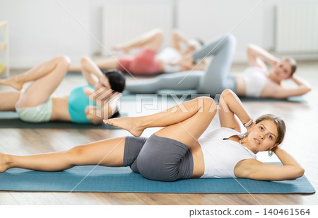 Girls Pilates marathon participant pulls elbows up to opposite knee, performs exhausting exercises Girls Pilates marathon participant pulls elbows up to opposite knee, performs exhausting exercises 140461564
