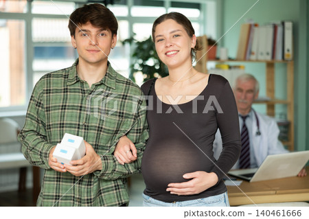 Pregnant woman and her husband came to a consultation with a doctor to get recommendations Pregnant woman and her husband came to a consultation with a doctor to get recommendations 140461666